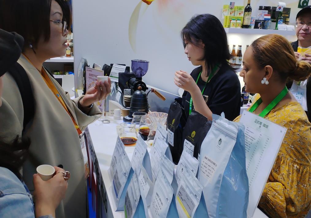“亚的斯咖啡”员工露丝&middot;特斯法耶 （右一）邀请观众品尝来自埃塞俄比亚的新品咖啡。新华社记者任军 摄