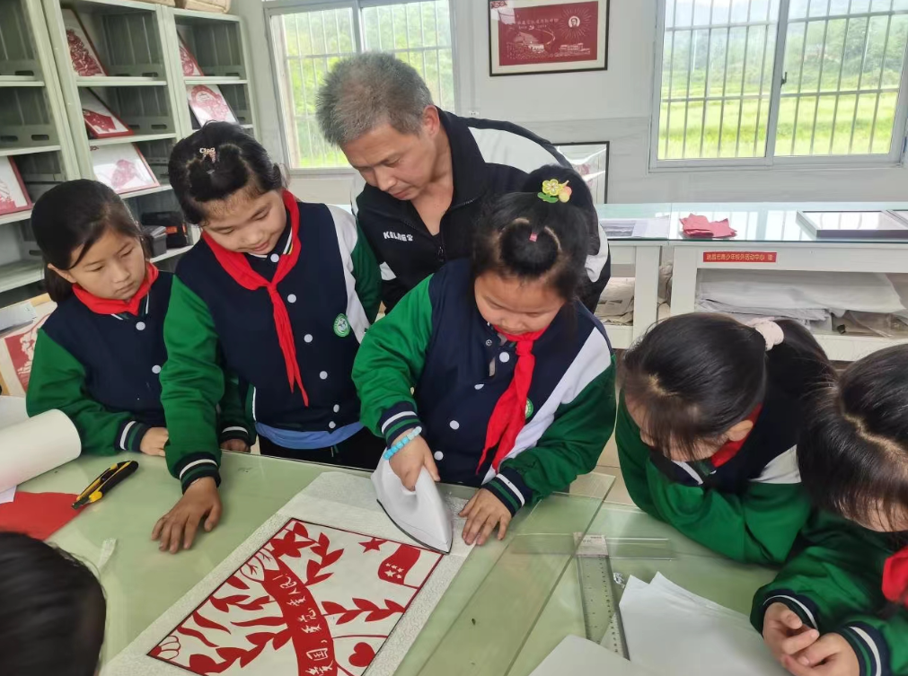 夏畈镇中心小学在剪纸装裱室组织学生开展“五一”剪纸装裱实践活动。孔潇琦/摄