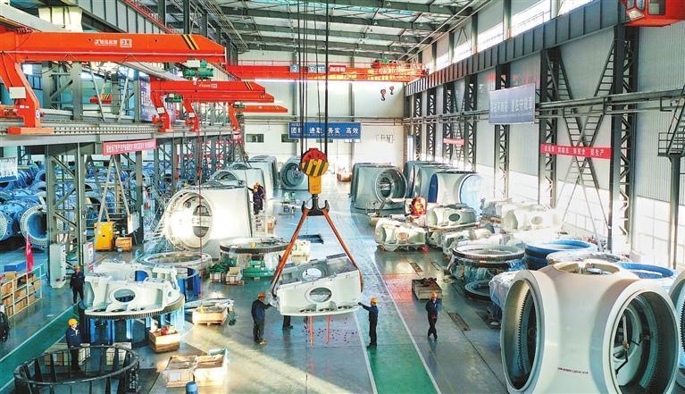 东方电气(酒泉)风电设备有限公司大型风电机组总装生产车间一派忙碌景象