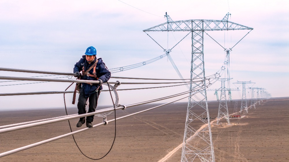 ▲施工人员在哈密-重庆±800千伏特高压直流输电线路工程(新疆段)安装间隔棒。通讯员 马元 摄