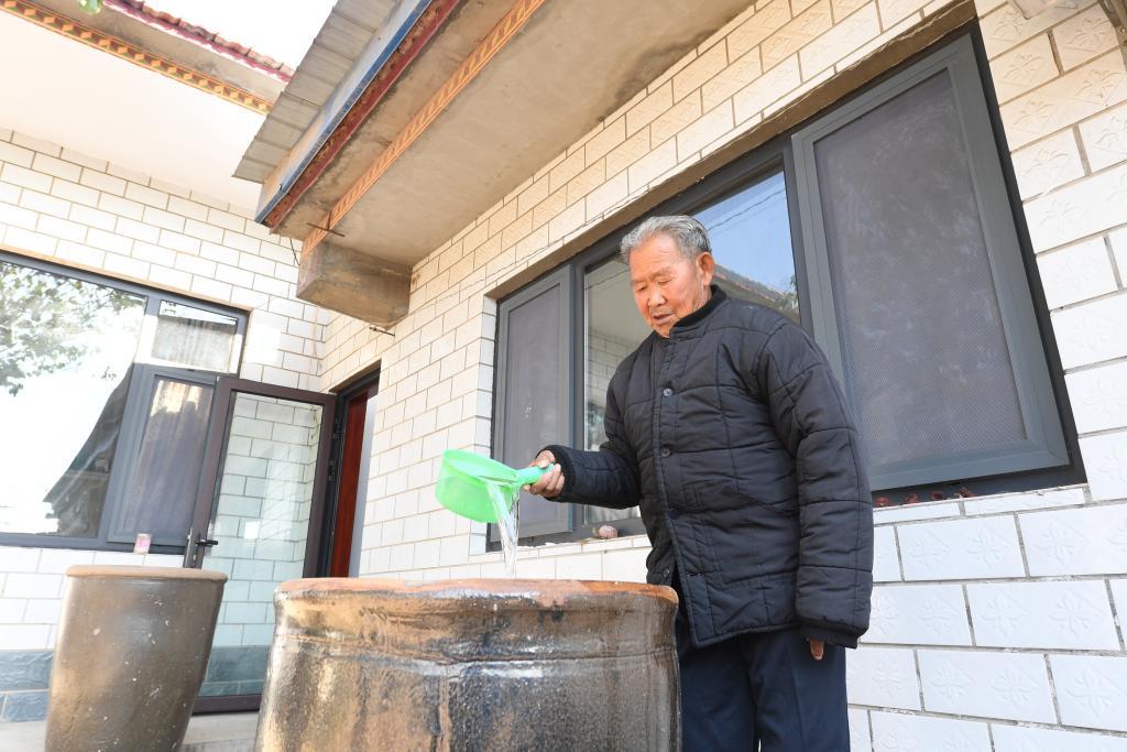 付书明家里原来储存饮用水的大水缸，如今用来储存雨水浇树种花。（受访者供图）
