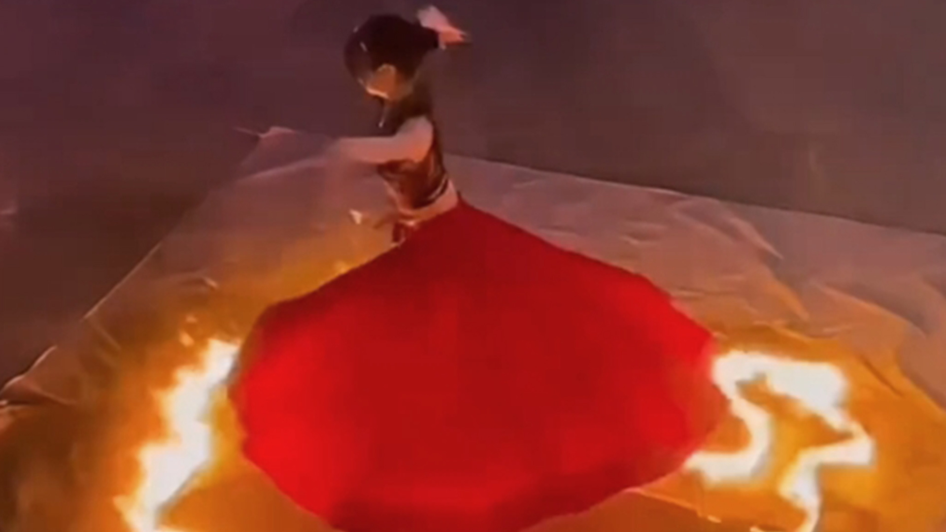 火裙舞表演裙摆意外被点燃，演员迅速脱下舞裙逃离，拍摄者：可能是风太大的缘故