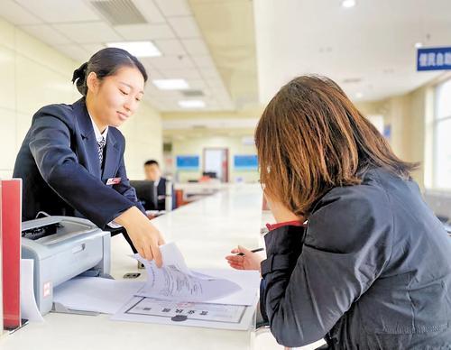 11月14日，一家企业工作人员（右）在张家口市下花园区政务服务大厅办理审批手续。 张家口市下花园区数政局供图