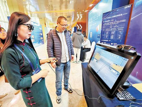 11月16日，在2024年中国物流学术年会企业展示区，中物联讯（北京）科技有限公司营销部经理张辉（右）正在向与会者介绍智慧物流三维虚拟仿真教学系统。 本报记者 刘杰摄