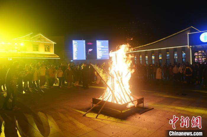 图为活动现场，参加活动人员及游客在篝火旁一起跳舞。中新社记者　李亚龙　摄