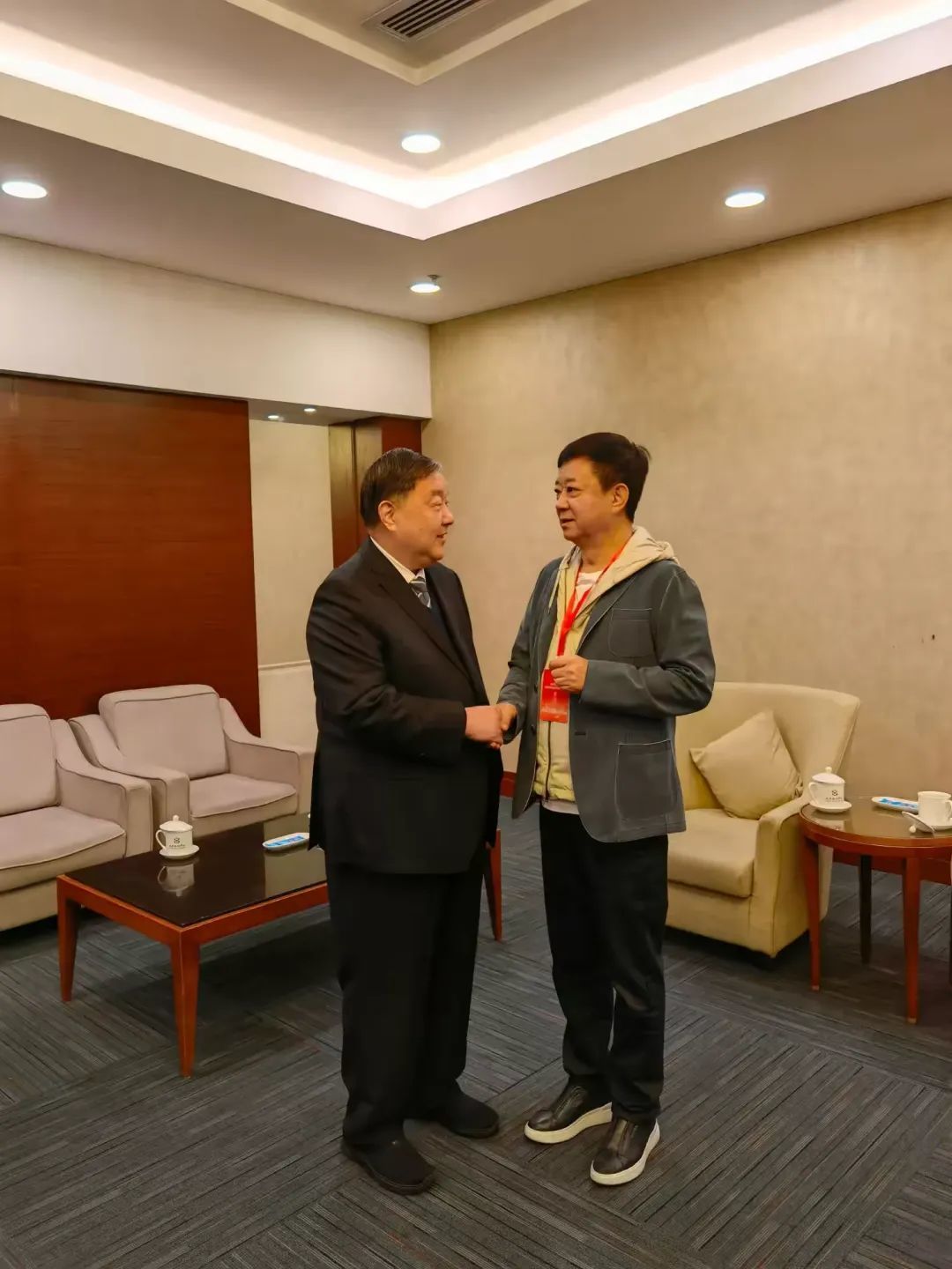 吴前进会长（左）与中华慈善总会形象大使、中央电视台著名主持人朱军（右）亲切交谈