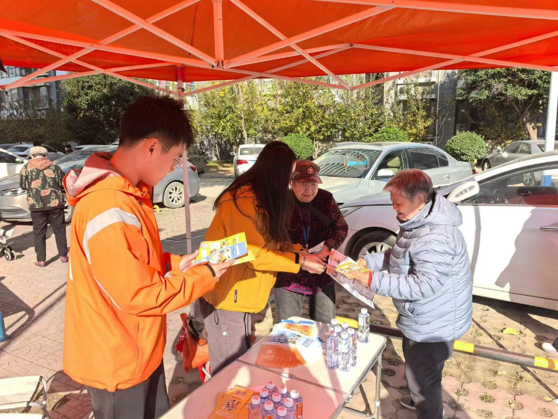 （图片说明：平安志愿者发放金融知识折页）