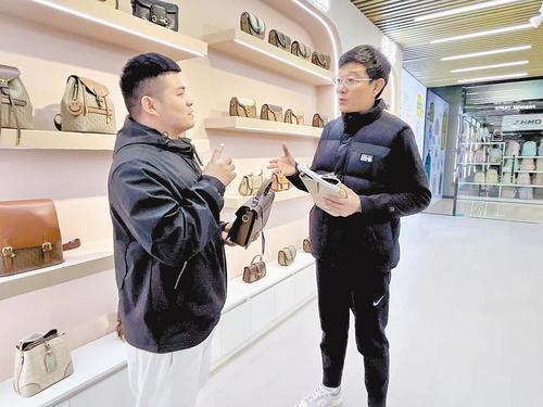 11月11日，白沟跨境电商公共服务平台经理赵荫卯（右）向商户了解跨境电商业务开展情况。本报记者 寇国莹摄