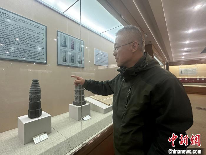 图为肃州区博物馆副研究馆员范晓东在讲解程段儿造像石塔 田鹏鹤 摄