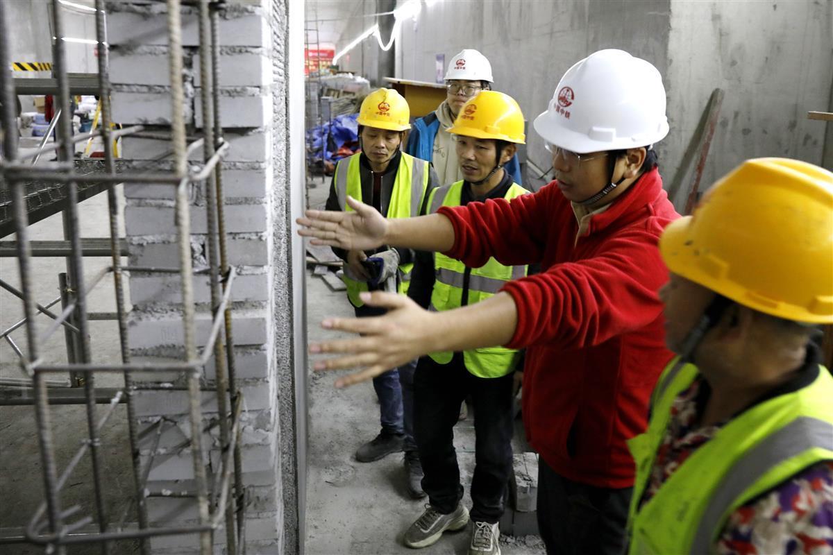 武汉地铁12号线坚持首件验收样板引路，图为工程师向作业人员对施工标准进行交底。袁永华 摄.jpg