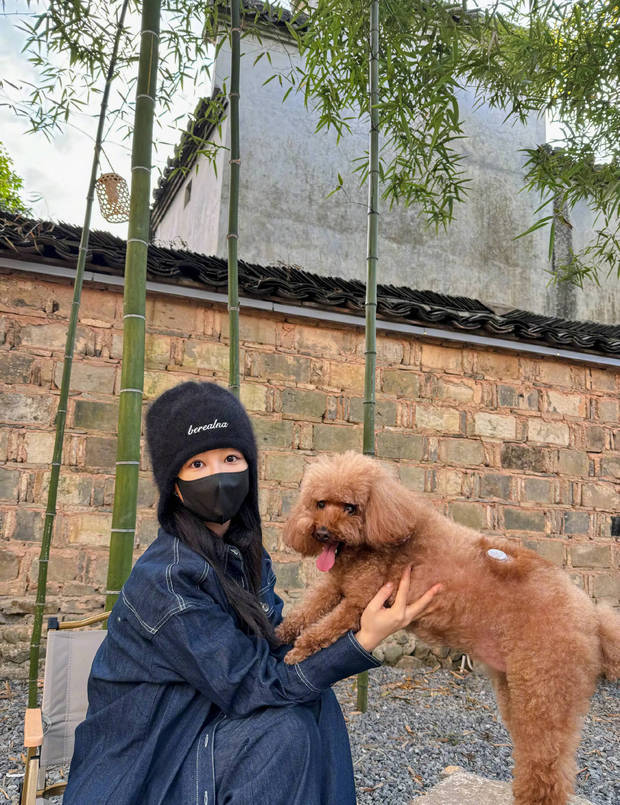 杨紫托着狗狗的上半身拍照，一人一狗都非常可爱。