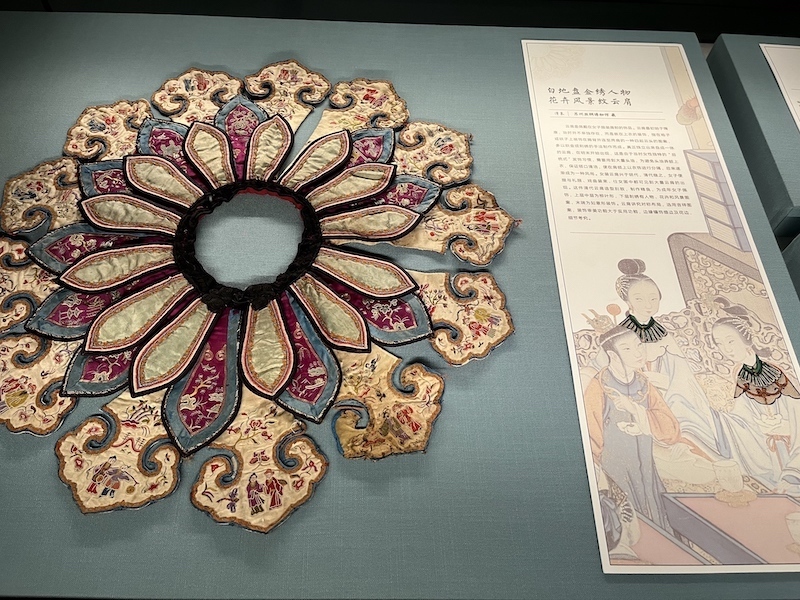 展览现场，白地盘金绣人物花卉风景纹云肩，苏州丝绸博物馆藏