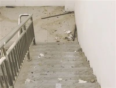 贵溪市沿河路地下停车场楼梯间内,废弃塑料袋、水瓶、烟蒂等杂物随意丢弃在楼梯和角落。