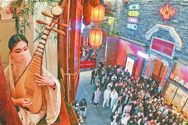 11月20日，南昌万寿宫历史文化街区，身着汉服的演员坐在窗边演奏琵琶，动听的旋律吸引了众多游客驻足观赏。