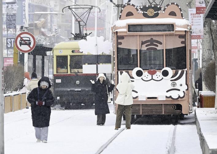 游客在雪中与54路文旅专列合影留念。