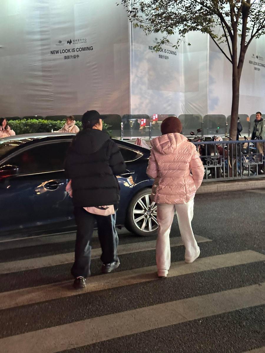 汤唯手持糖葫芦，边走边品尝，显得格外轻松自在。
