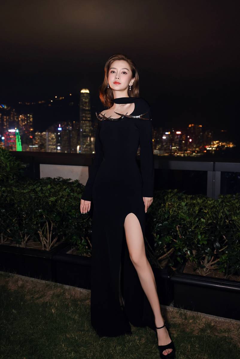 杨颖在维多利亚港边悠闲散步。
