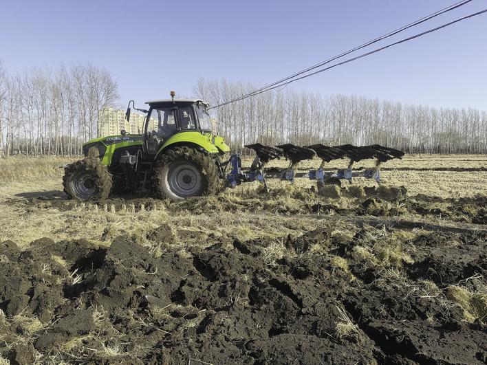 凤财种植家庭农场使用翻转犁翻开土壤,把富含养分的稻秆翻转到下层。 于鑫雨 摄