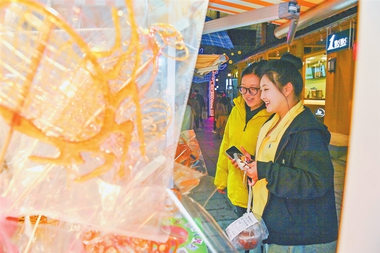 游客正在购买南昌幽兰糖画等创意产品。