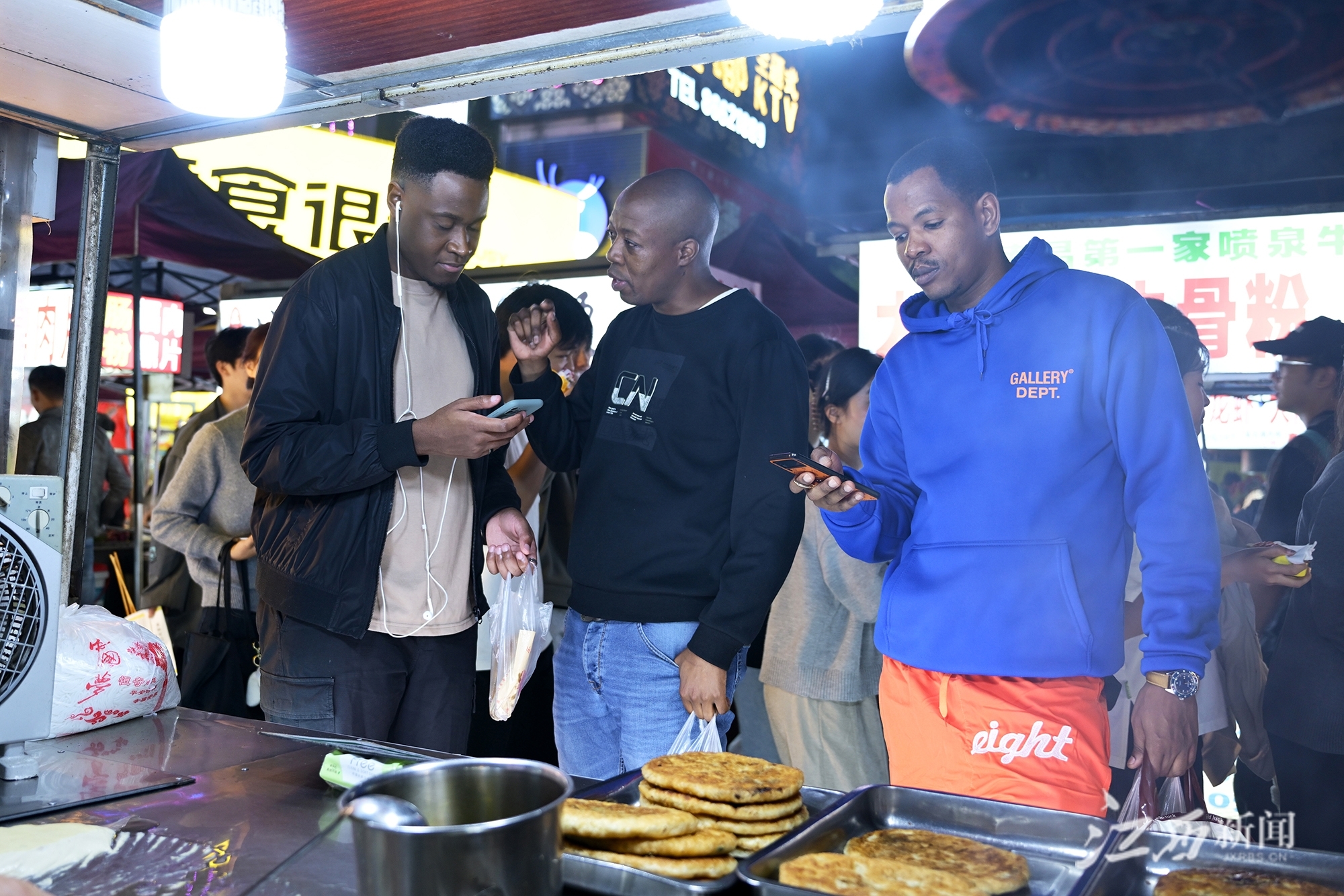 ▲外国友人在紫荆夜市品尝美食。