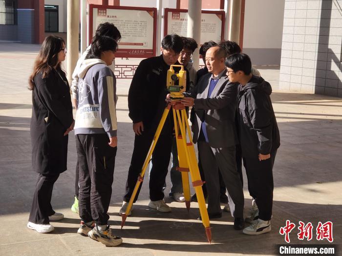 吕安岭(右二)在校园内指导学生做测绘。赵晓 摄
