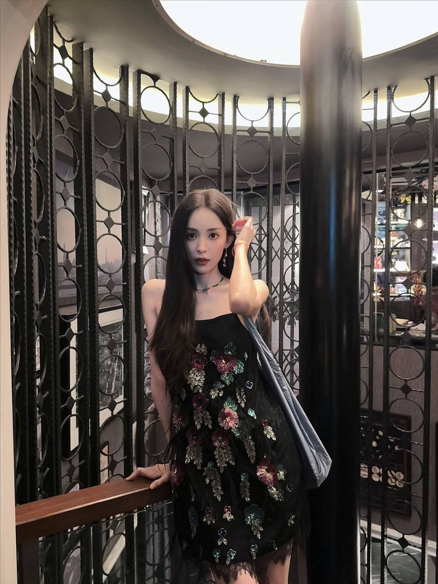 娜扎左手撩起头发，气质出众。
