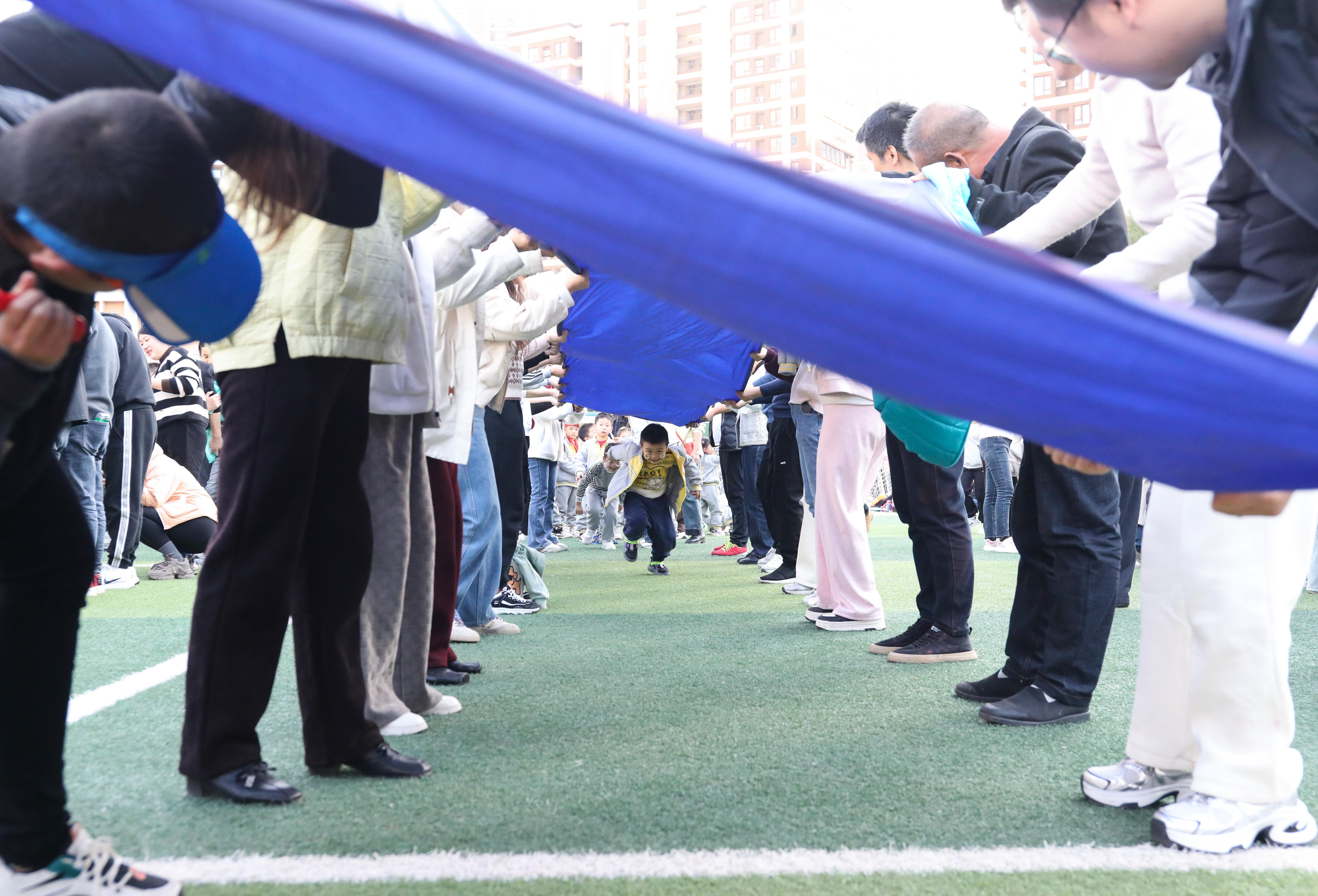 (2024年11月30日,家长与幼儿在亲子运动会上开展趣味运动游戏。 王璇 摄)