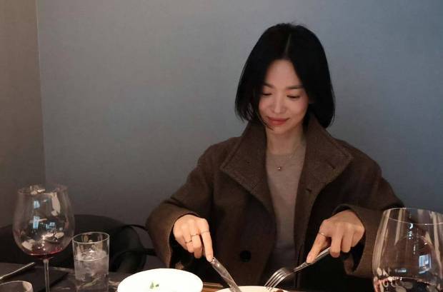 宋慧乔用刀叉吃着美食，恬静温柔。