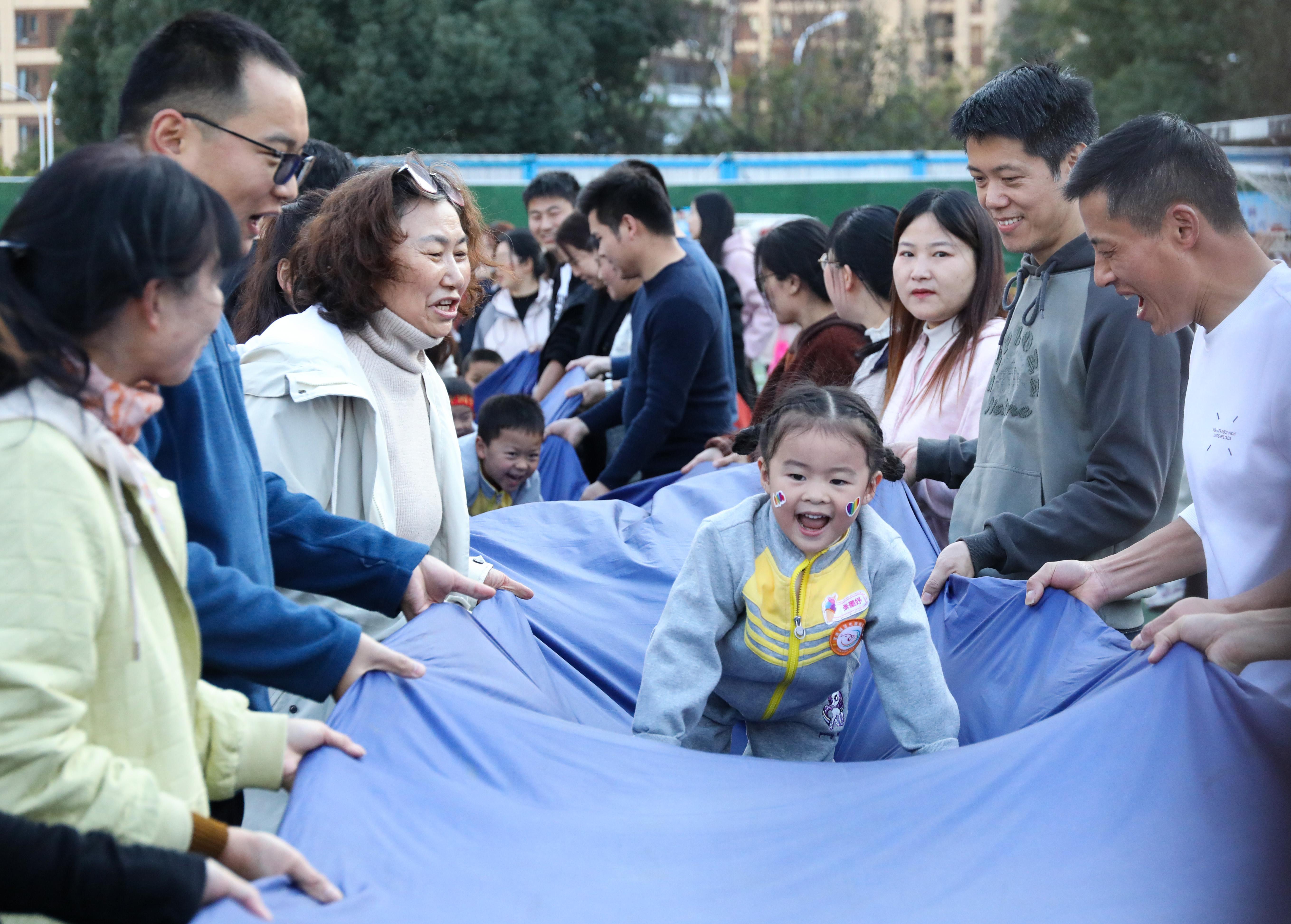 (2024年11月30日,家长与幼儿在亲子运动会上开展趣味运动游戏。 王璇 摄)