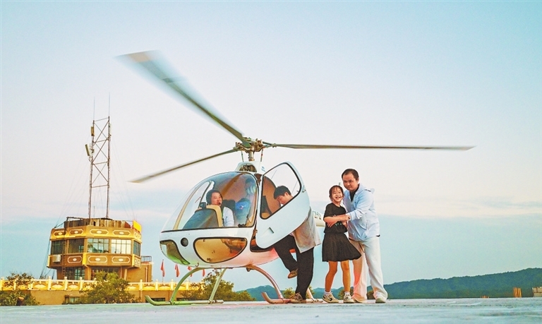 游客在景区体验直升机项目。