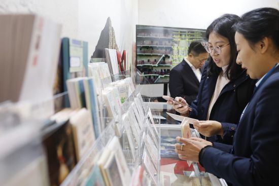 参观者在敦煌主题邮局了解敦煌元素明信片　中新网记者　殷立勤　摄