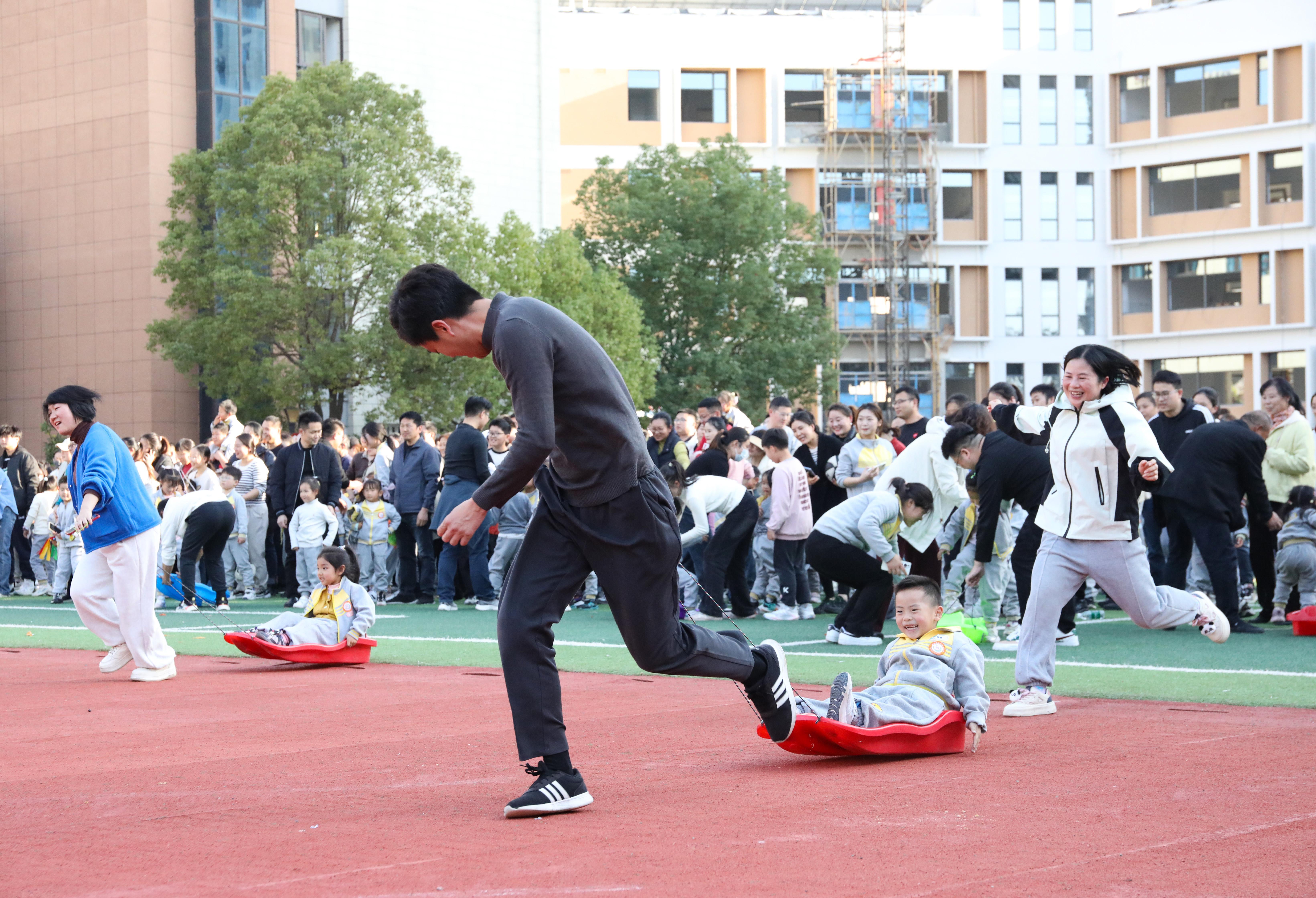 (2024年11月30日,家长与幼儿在亲子运动会上开展趣味运动游戏。 陈家乐 摄)