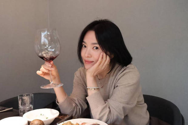 宋慧乔单手举着红酒杯，优雅迷人。
