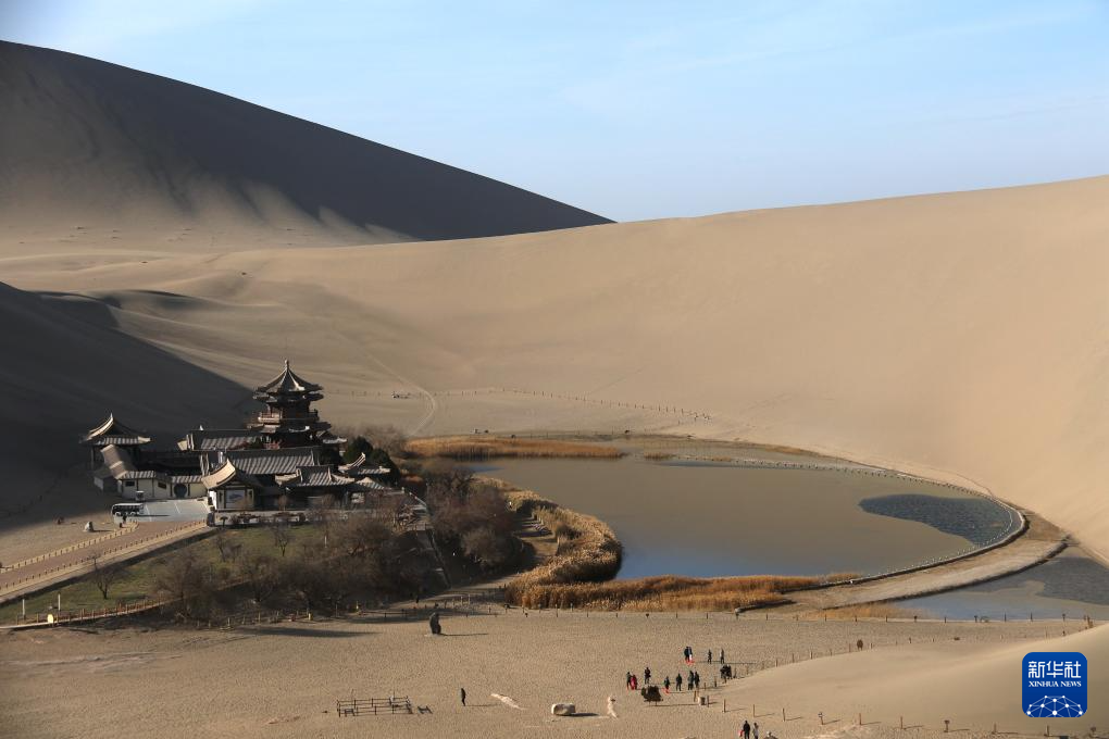 12月1日，游客在甘肃省敦煌市鸣沙山月牙泉景区游览。