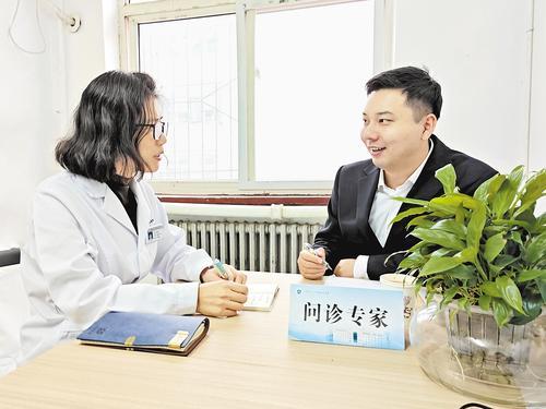 11月14日,问诊专家匡明杰(右)在科研门诊接诊。 本报记者 袁 铮摄