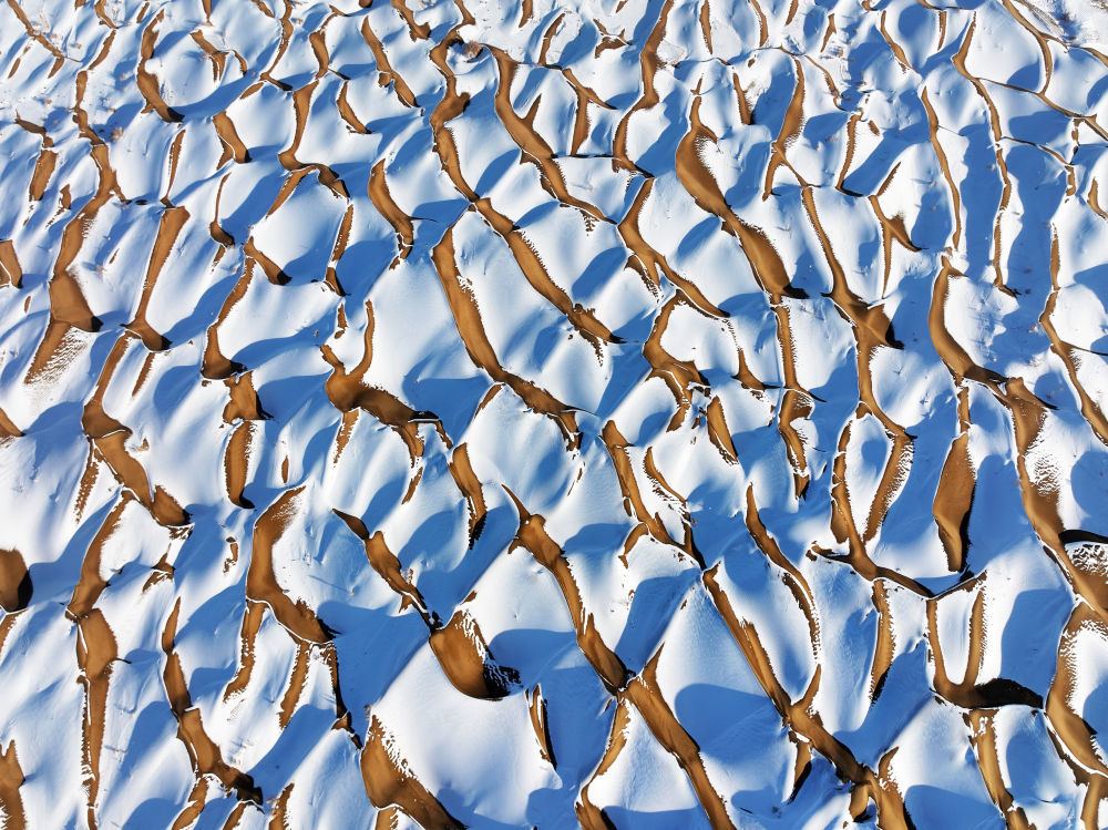 12月12日，在甘肃酒泉阿克塞哈萨克族自治县拍摄的雪后库姆塔格沙漠景观（无人机照片）。新华社发（高宏善　摄）