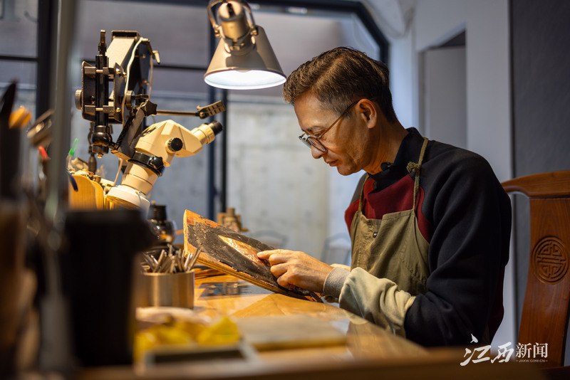 ▲吴刚在工作台前錾刻（图：陆文青）