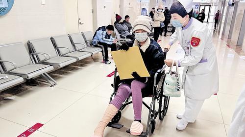 12月9日,在白求恩国际和平医院,白求恩志愿服务队的志愿者帮助腿脚不便患者就医。张彬楠摄