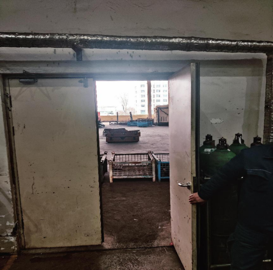 某企业拆解车间的疏散门向内开启，且门外的疏散通道被阻挡。