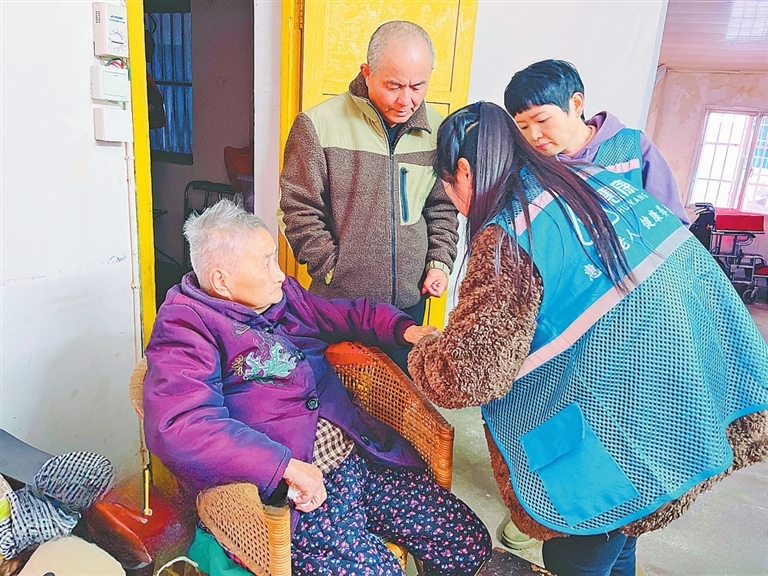 工作人员上门与老人沟通居家适老化改造方案。　　本报全媒体记者 陈 璋摄