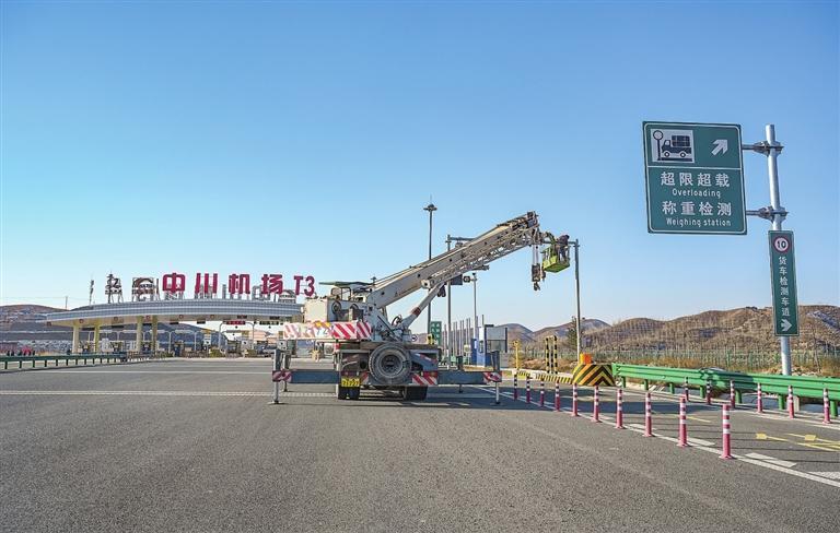 工人正在中川机场T3收费站口安装交通指示设备