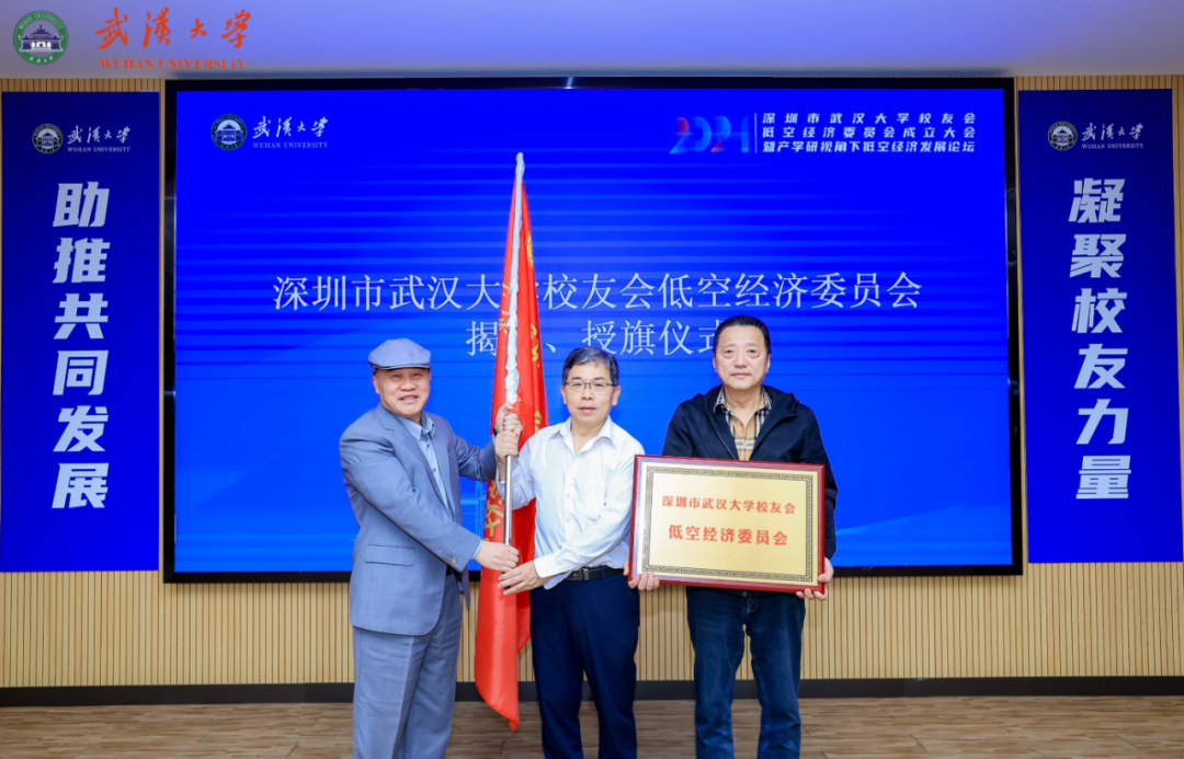 图为：刘少雄会长向黄晓明主席和许凡联席主席授会旗和匾牌