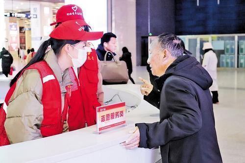12月7日,在石家庄火车站为民服务台,河北省爱心公益协会的志愿者正在为旅客提供咨询服务。 本报记者 赵泽众摄