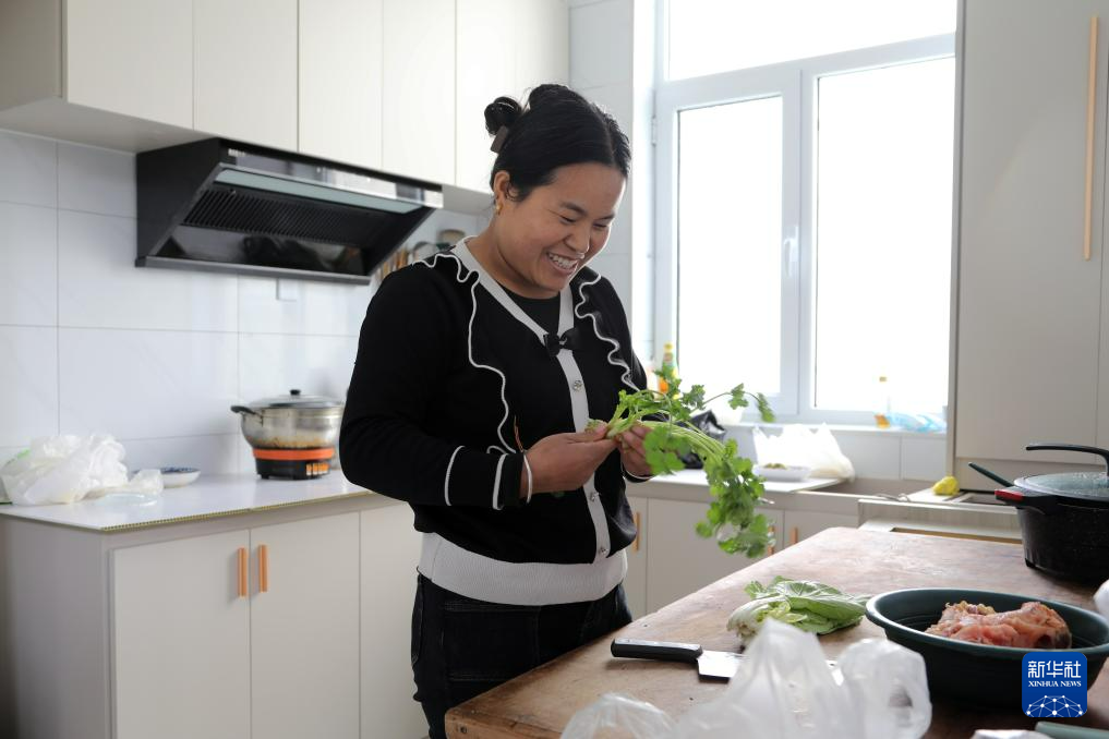 12月11日，在积石山县刘集乡团结村集中安置点，村民龚顺莲在厨房做饭。新华社记者　马莎　摄