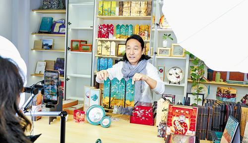 12月2日，甲舍文创礼物馆主播兼设计师大林正在通过直播推介中国风水晶四联小屏风。 本报记者 王永晨摄