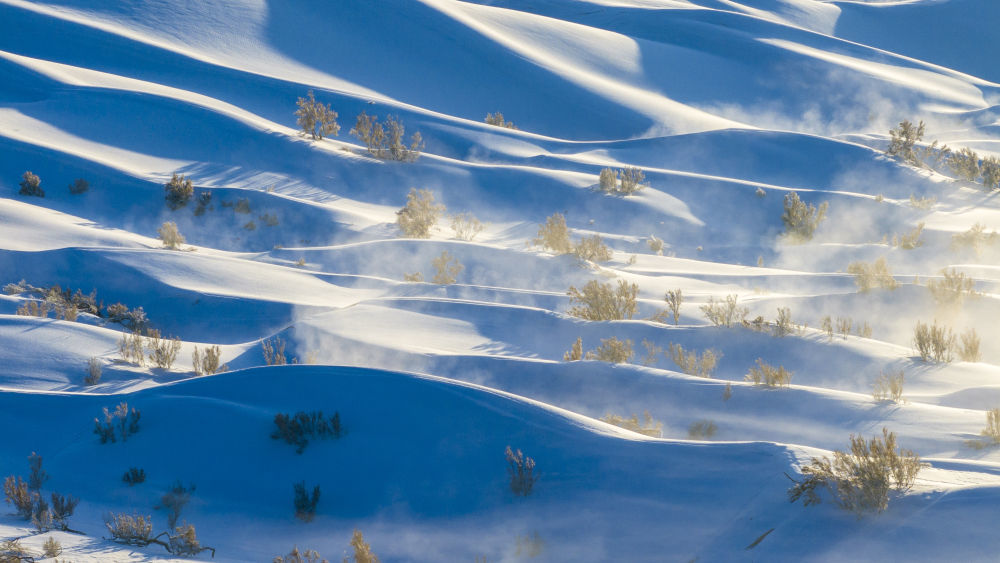 12月12日，在甘肃酒泉阿克塞哈萨克族自治县拍摄的雪后库姆塔格沙漠景观（无人机照片）。新华社发（高宏善　摄）