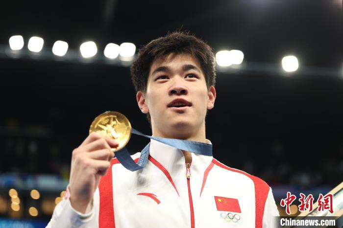 巴黎当地时间7月31日,在巴黎奥运会游泳男子100米自由泳决赛中,浙江籍选手潘展乐以46秒40的成绩打破世界纪录,夺得金牌。图为潘展乐展示奖牌。 中新社记者 富田 摄