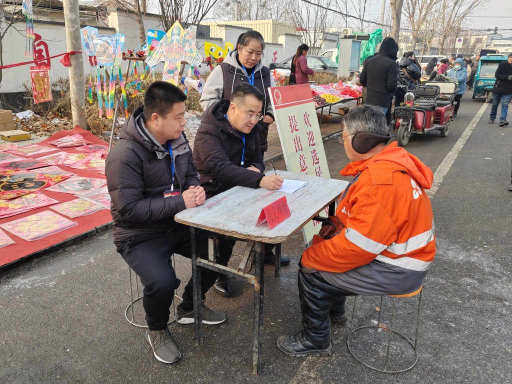 去年底,新安镇人大代表(左一和左二)正在集上接待群众。(资料片)正定县人大常委会供图