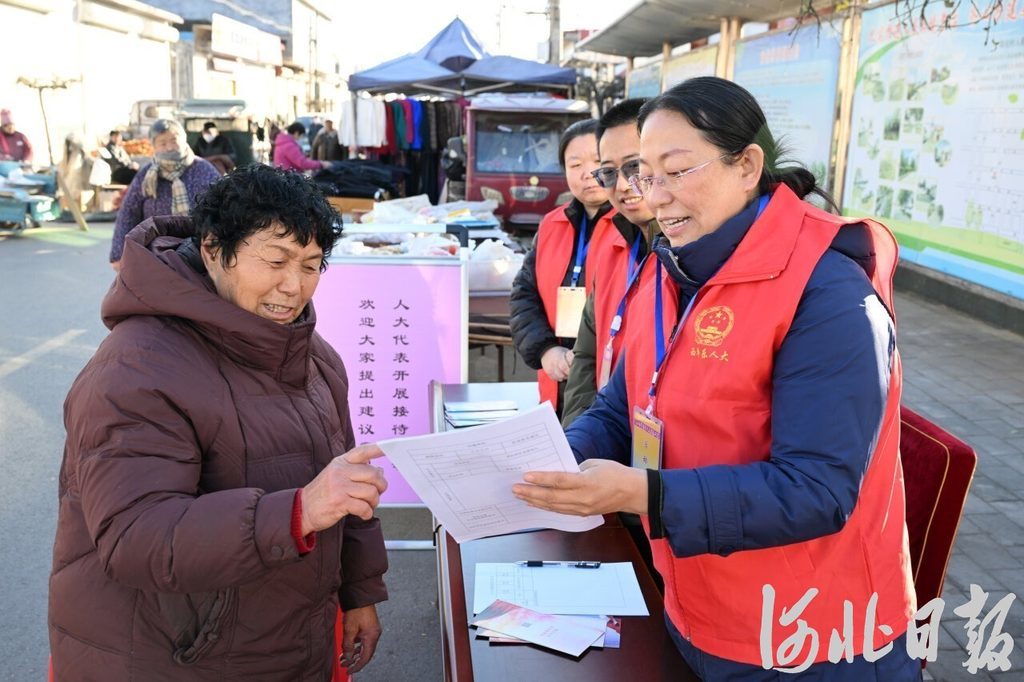 12月16日,正定县西平乐乡南化大集上,74岁的谷顺兰(左一)正向人大代表反映问题。河北日报记者史晟全摄