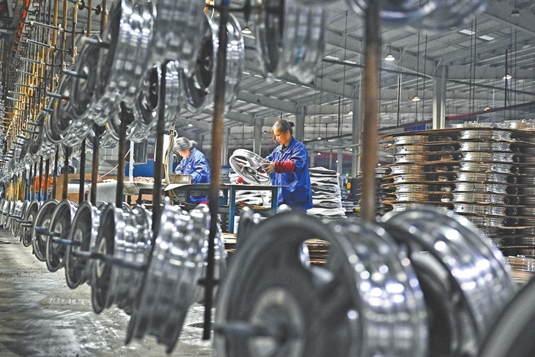 在江西今飞轮毂有限公司，工人利用再生铝制作各种轮毂产品。